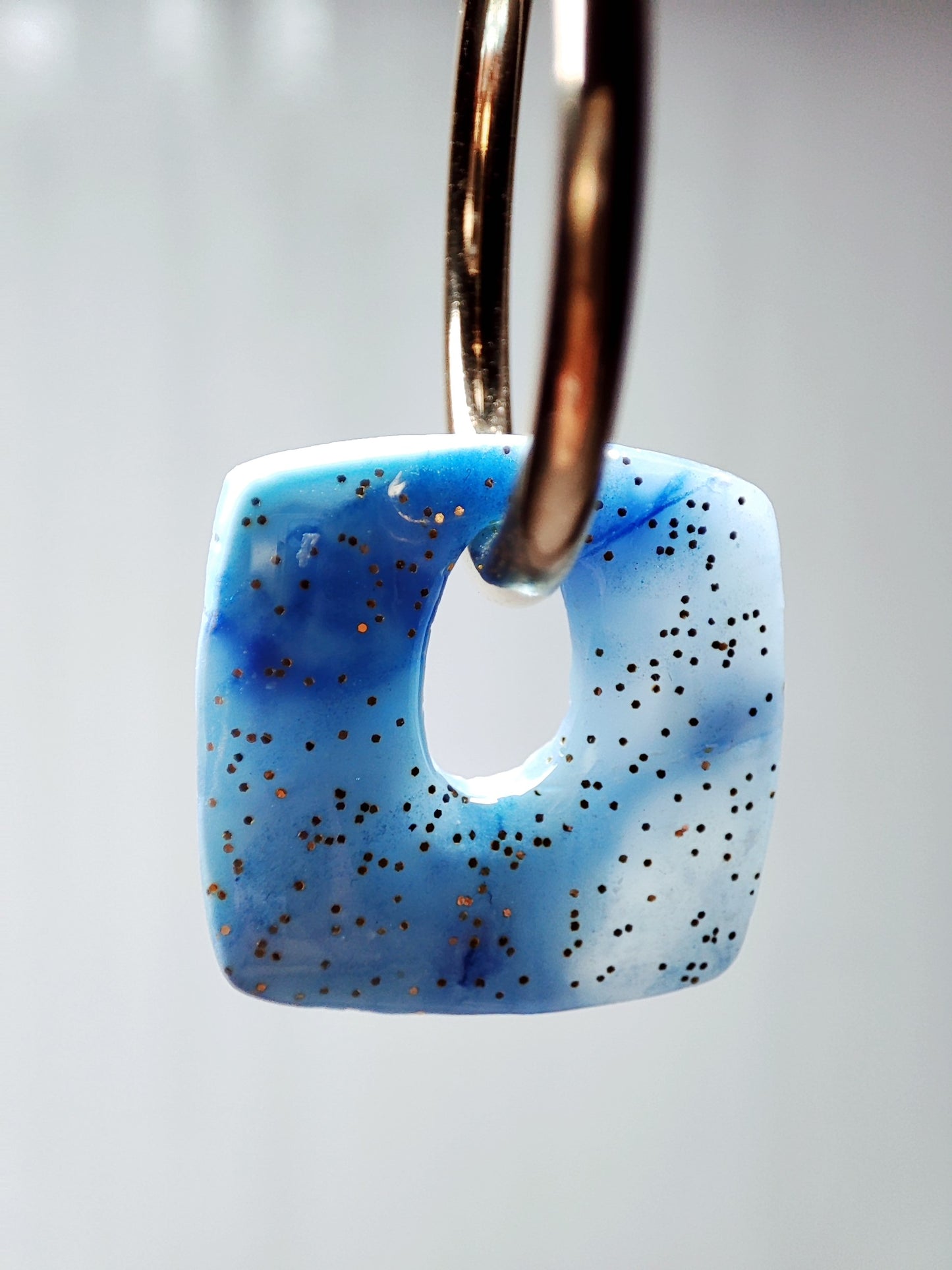 boucles d'oreilles modulables carrées bleu minéral doré pailleté gros plan par transparence