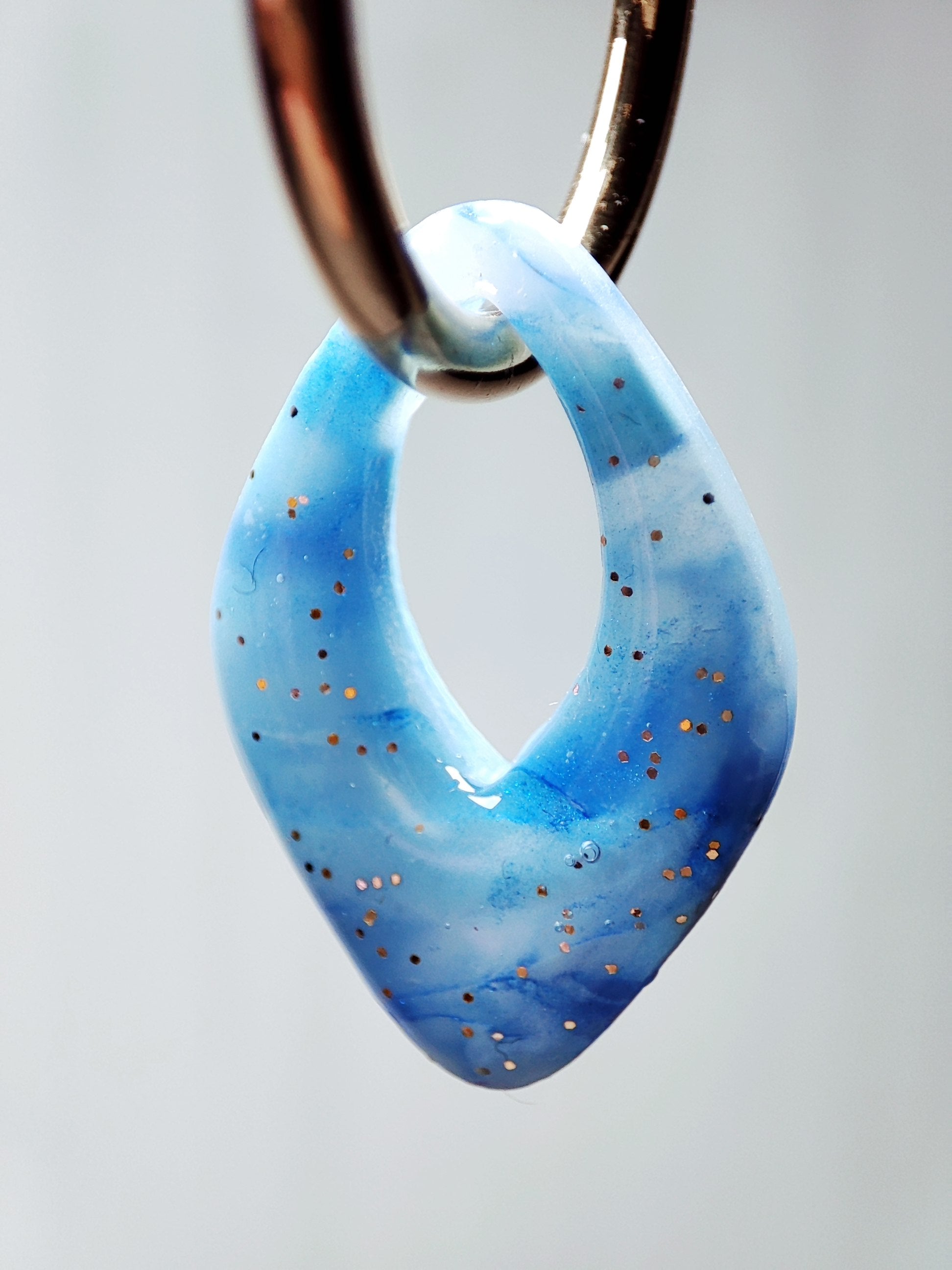 boucles d'oreilles modulables diamants bleu minéral doré pailleté gros plan par transparence