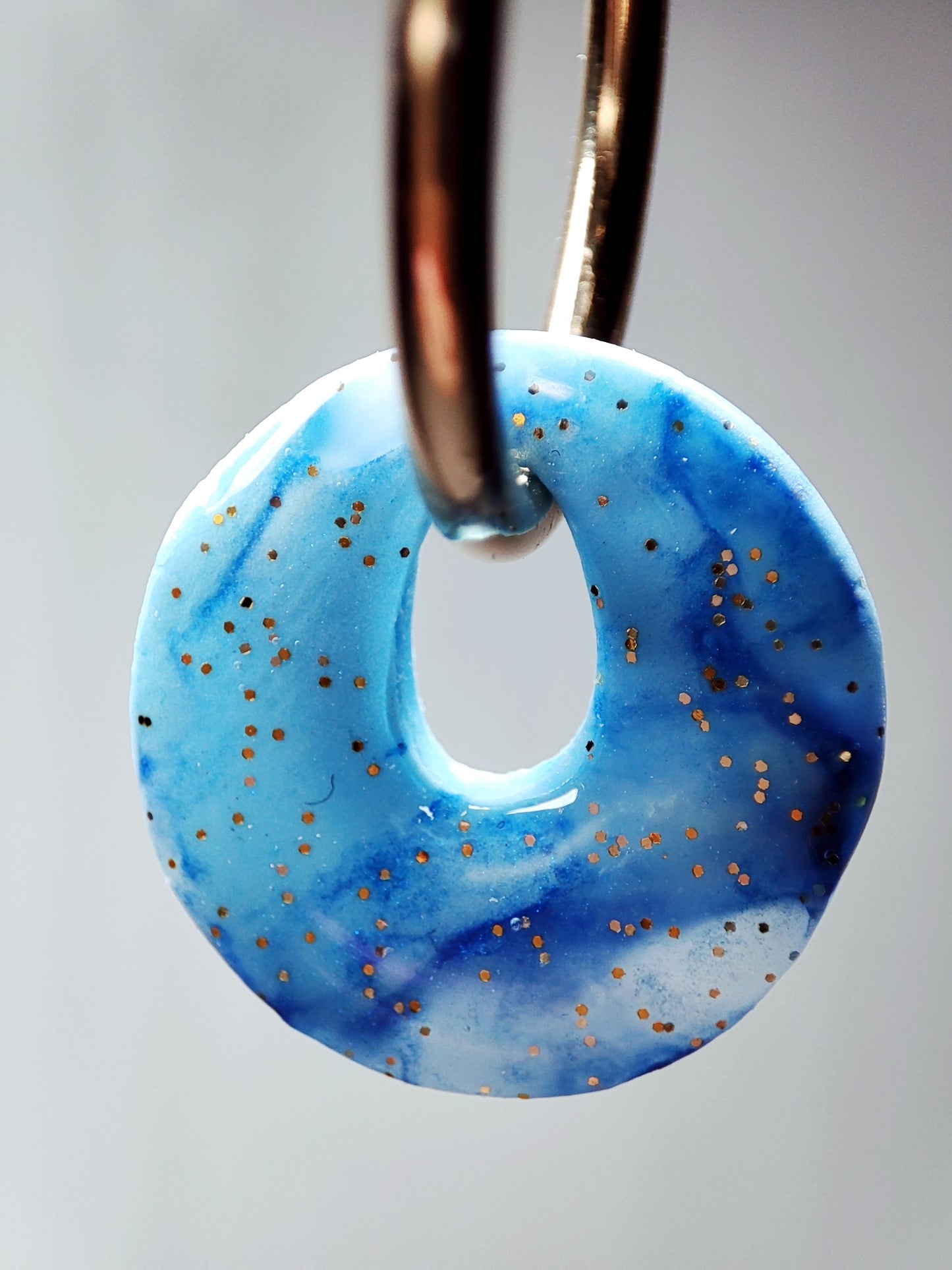 boucles d'oreilles modulables rondes bleu minéral doré pailleté gros plan par transparence